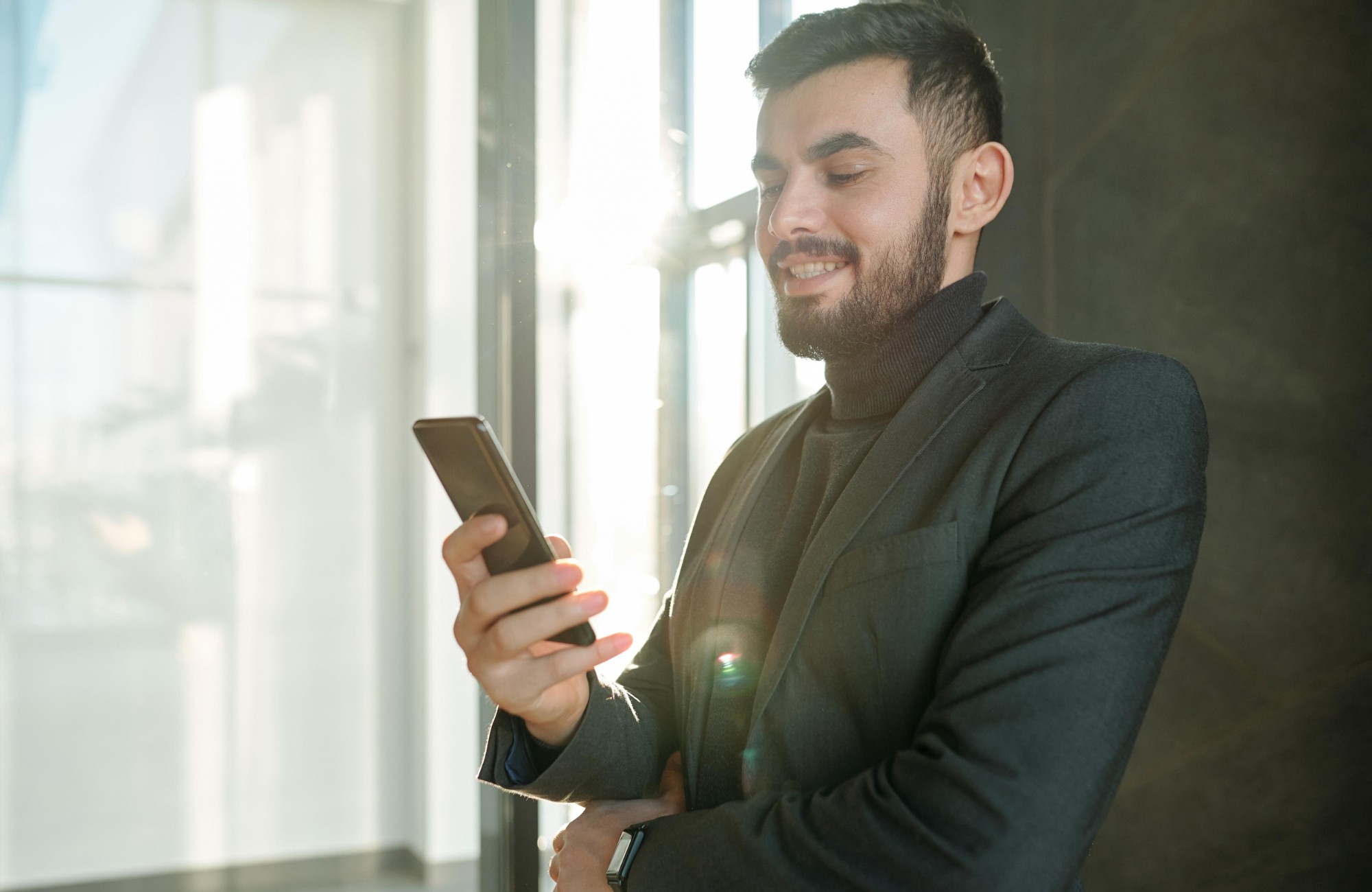happy-young-businessman-scrolling-in-smartphone-an-PSB4997.jpg
